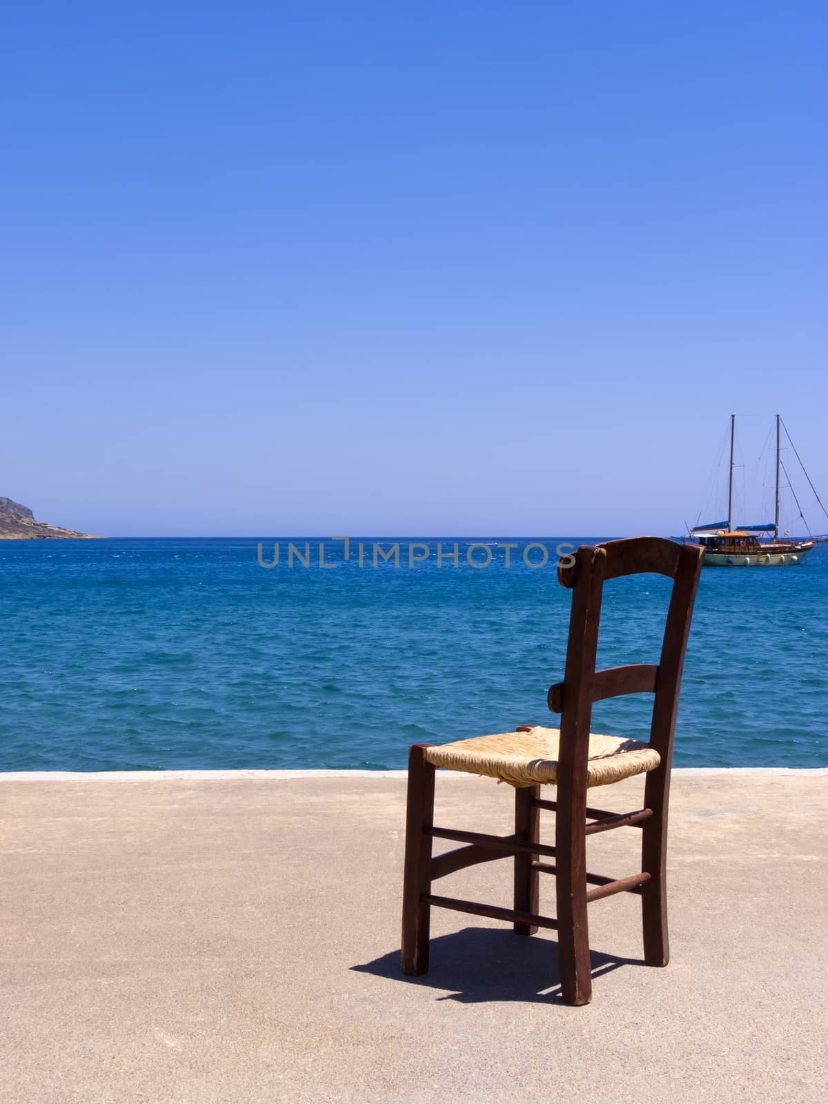 Old wooden chair near the sea in Crete, Greece