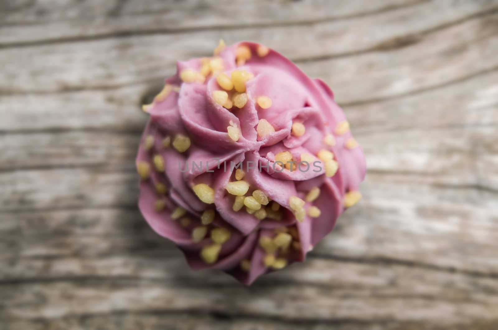 Bright Pink Frosted Cupcake On A Wooden Background