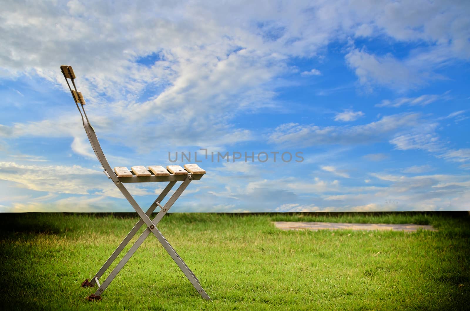 Old chair on blue sky and white cloundl background