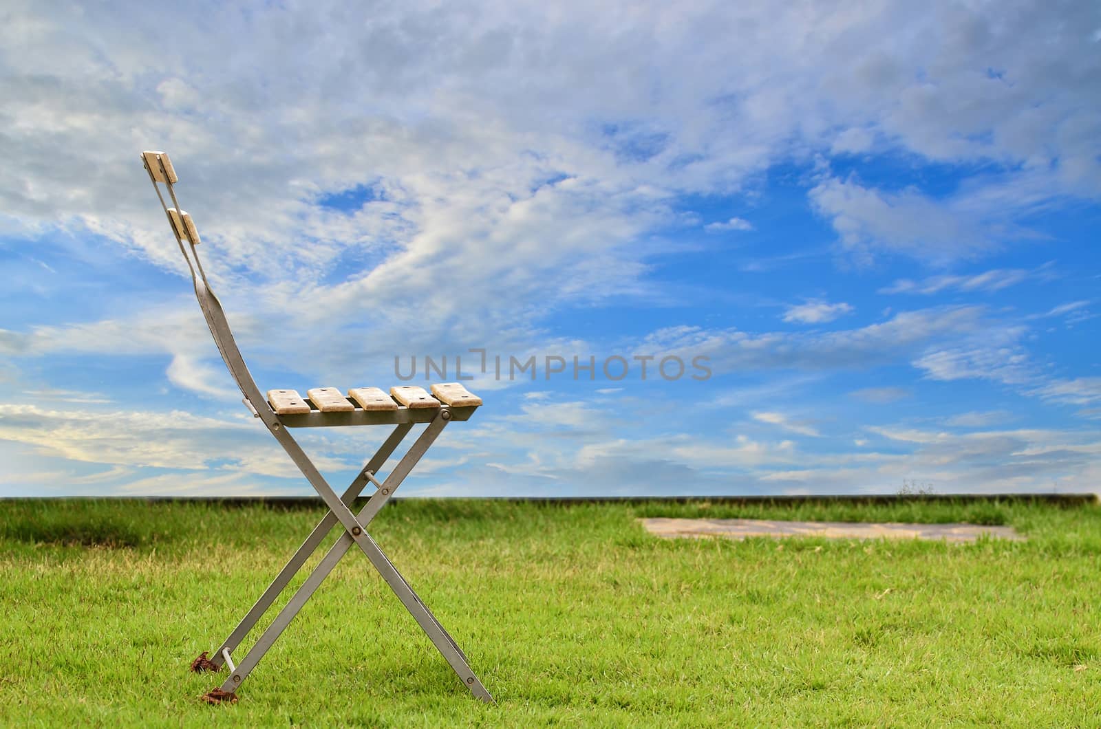 Old chair on green grass by raweenuttapong