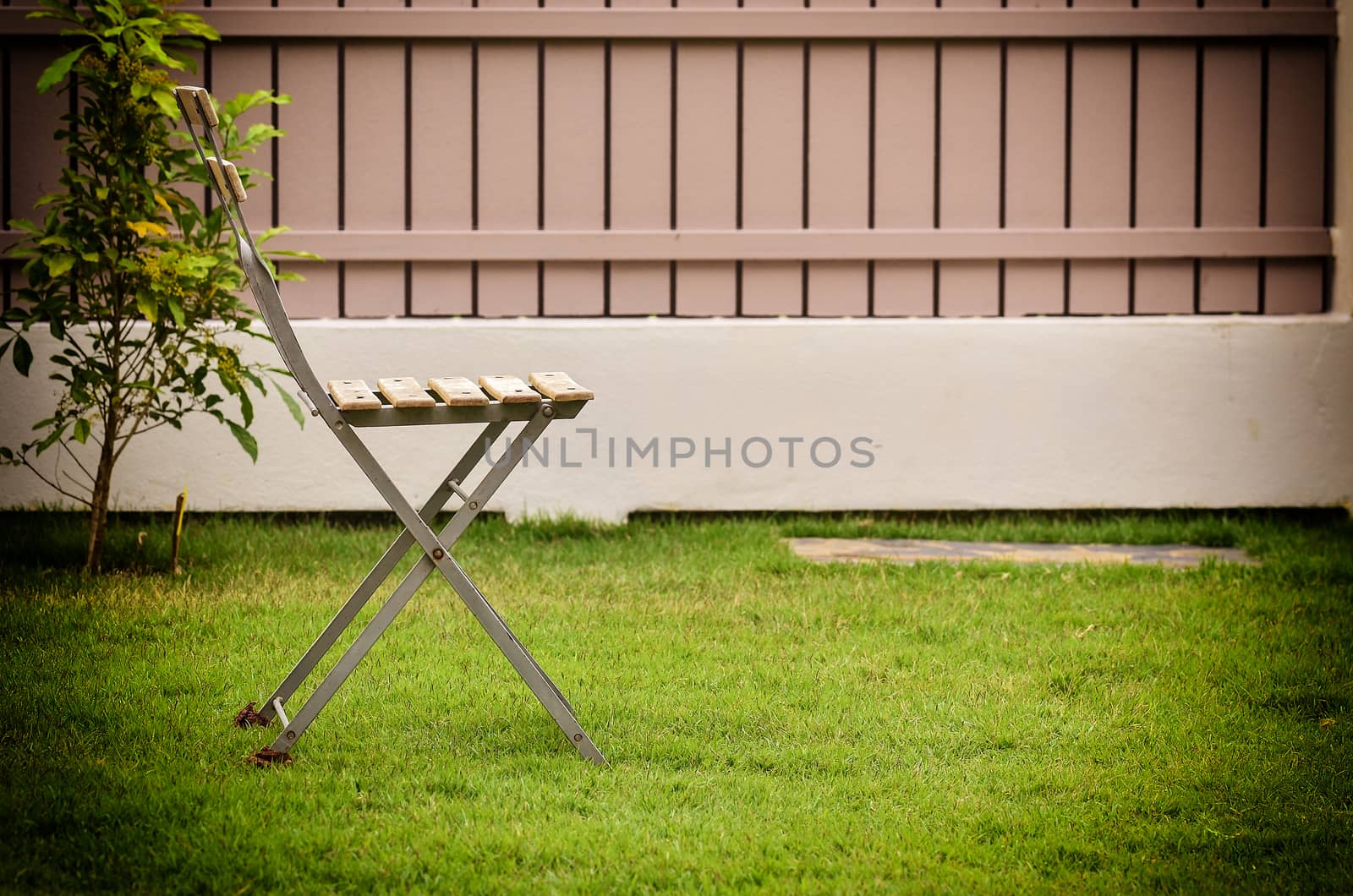 Old chair on green grass in vintage light