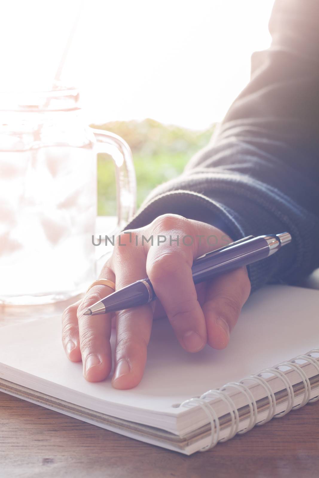 Woman hand with pen writing on notebook with vintage style