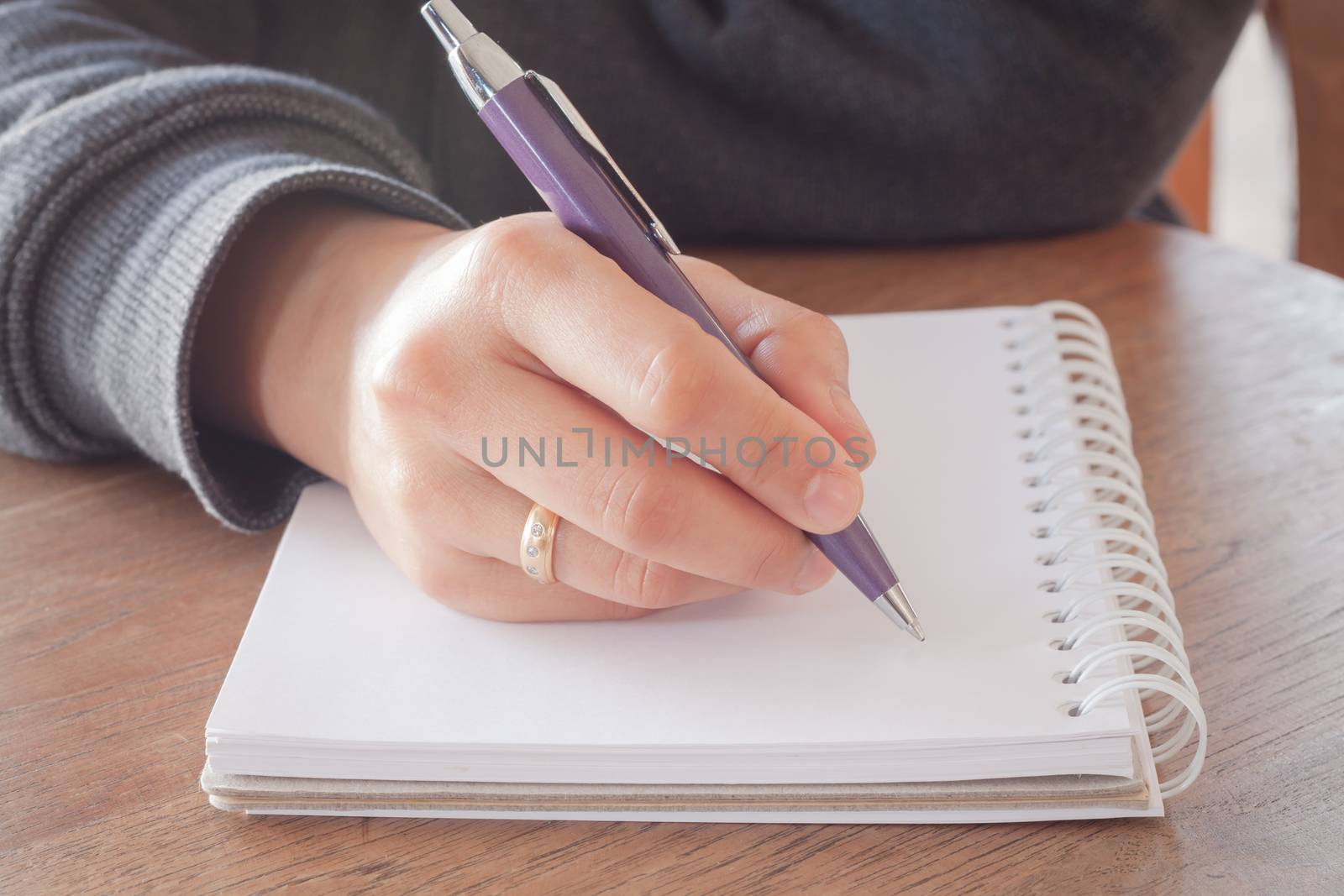 Woman hand with pen writing on notebook with vintage style