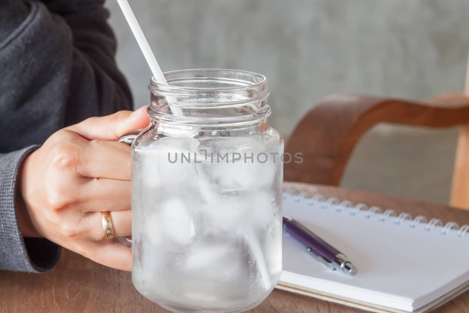 Woman's hand holding a cold glass of water, stock photo
