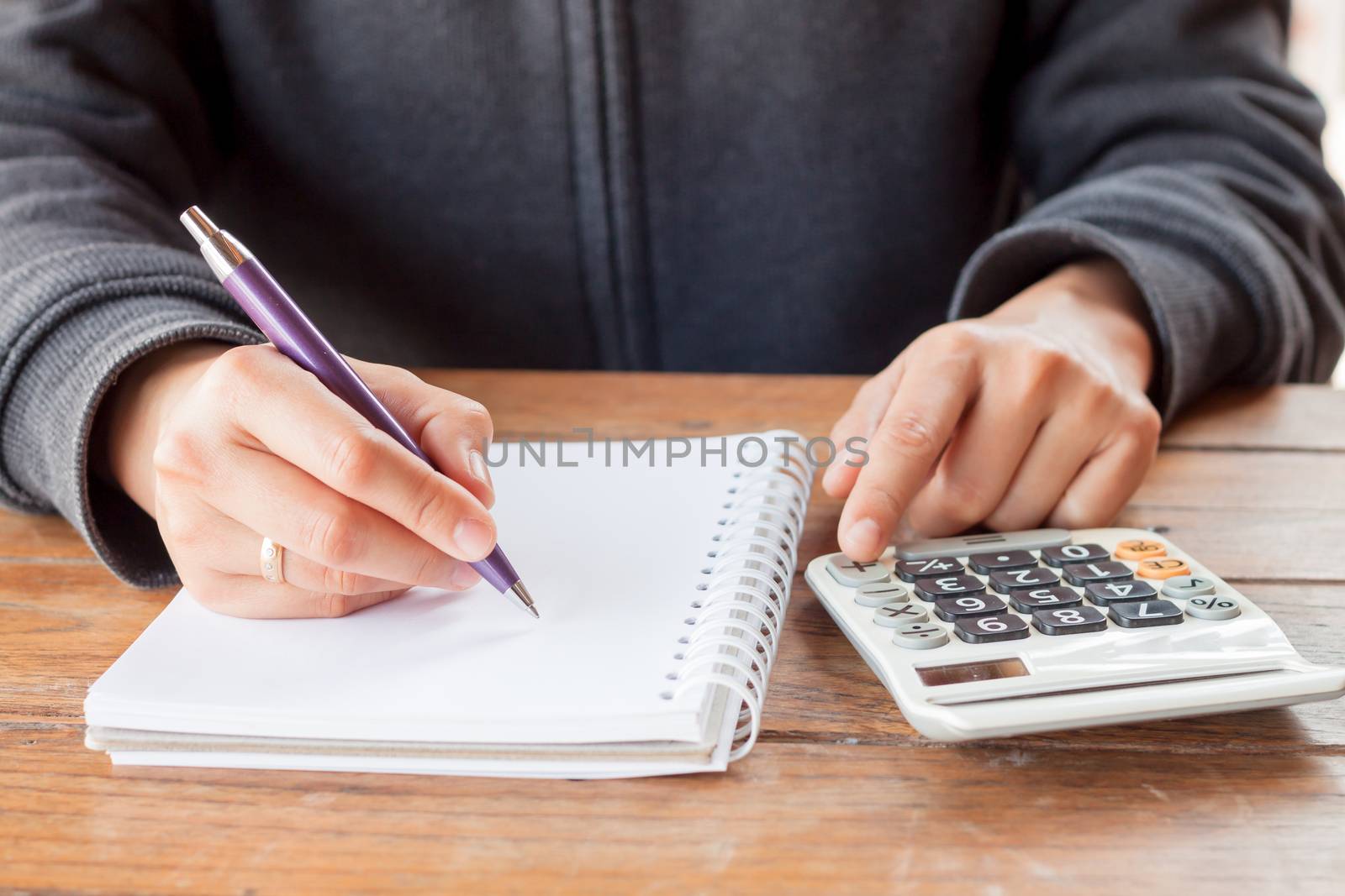 Woman hand with pen writing on notebook, stock photo