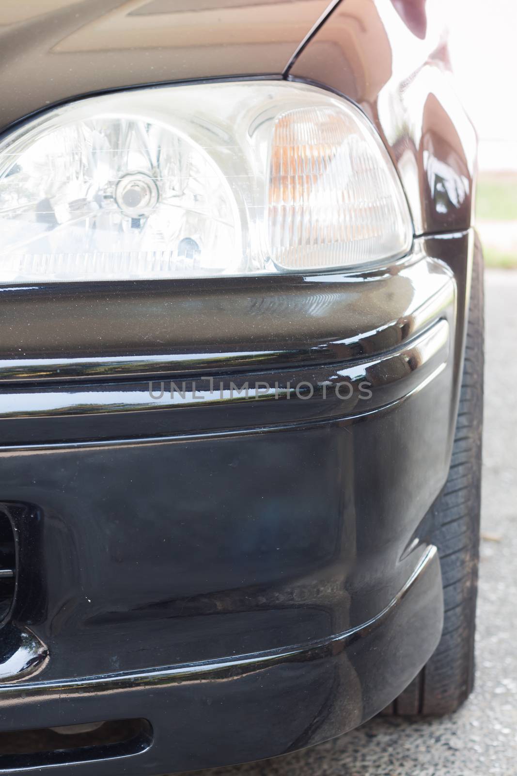 Closeup headlight of black coupe, stock photo