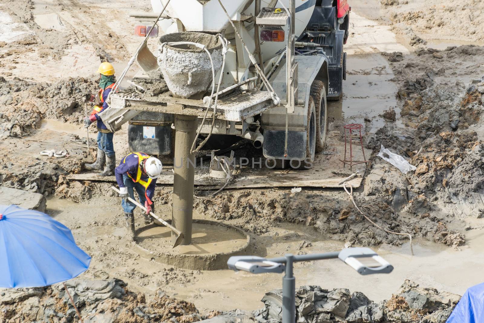 Construction workers are preparing pump for concrete for pouring.