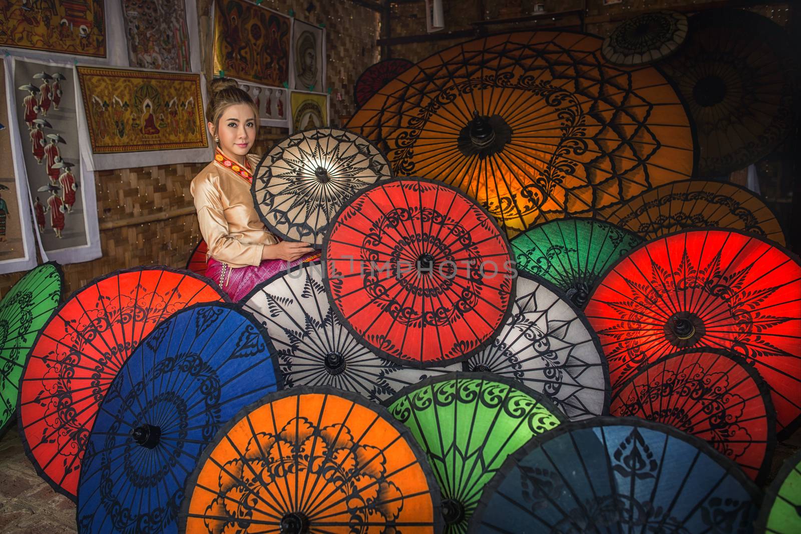 Asian Women in Umbrella Souvenier Shop in New Bagan in Myanmar i by chanwity