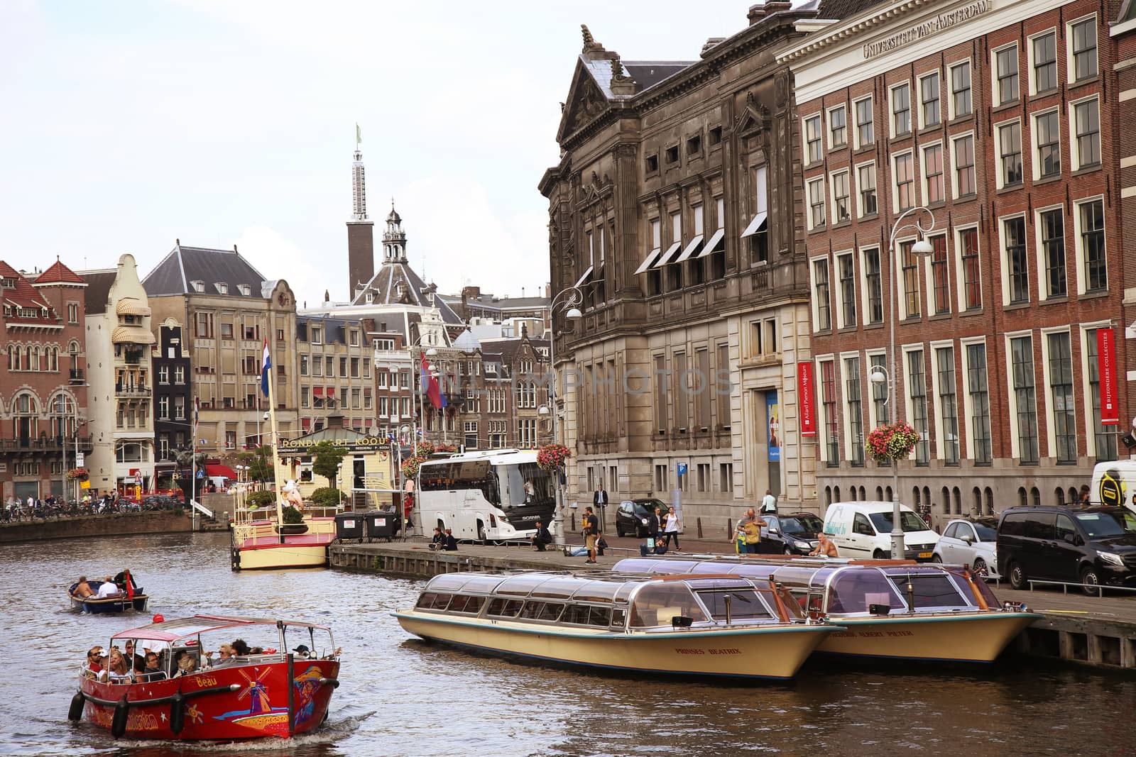 AMSTERDAM, THE NETHERLANDS - AUGUST 19, 2015: View on Rokin from bridge Doelensluis. Street life, Canal, tourists, bicycle and boat in Amsterdam. Amsterdam is capital of the Netherlands on August 19, 2015.