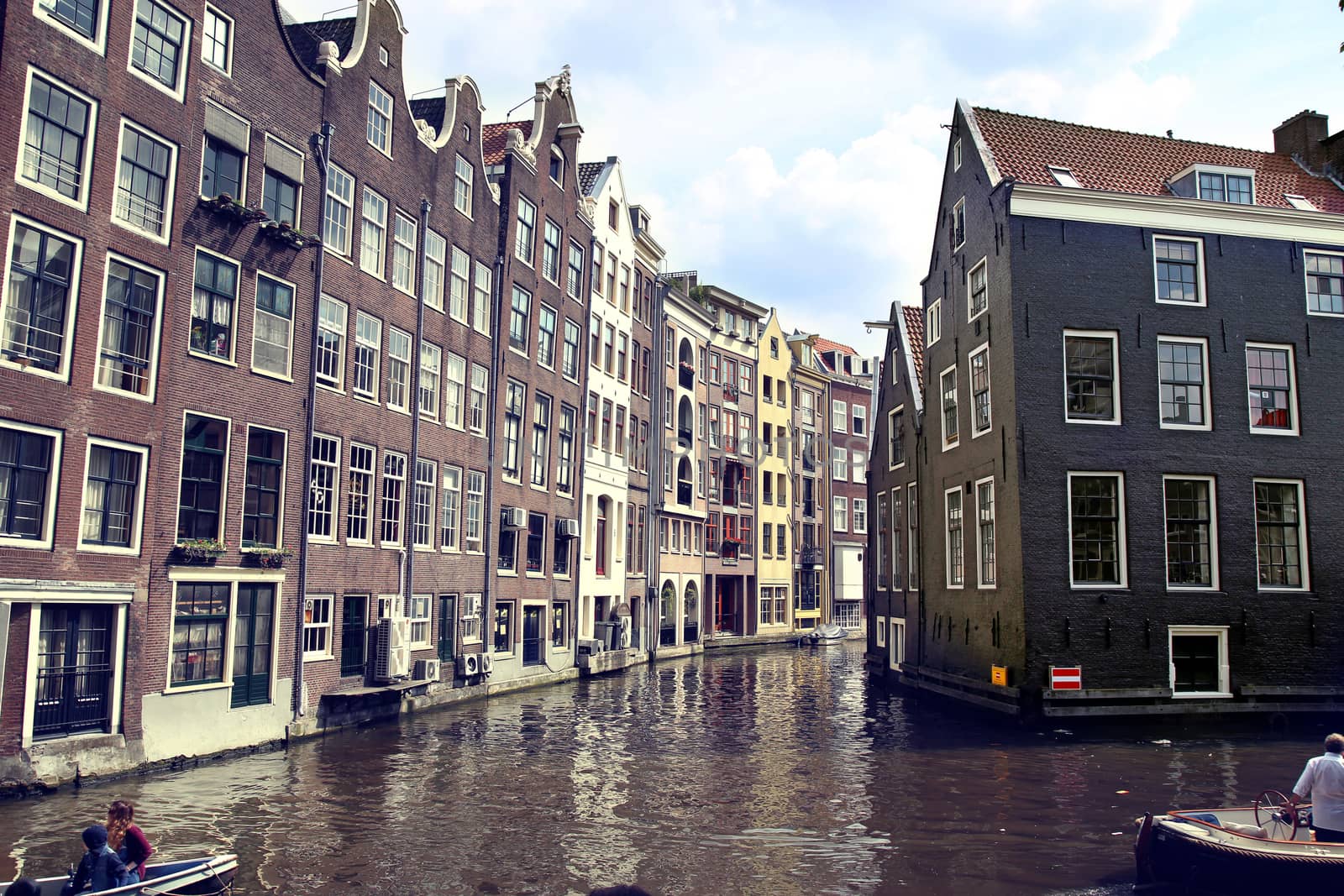 AMSTERDAM, THE NETHERLANDS - AUGUST 19, 2015: View on Oudezijds Kolk canal, street life, bicycle, canal in Amsterdam. Amsterdam is capital of the Netherlands on August 19, 2015.