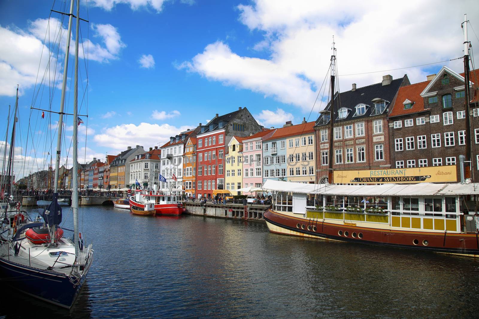 COPENHAGEN, DENMARK - AUGUST 15, 2016: Boats in the docks Nyhavn, people, restaurants and colorful architecture. Nyhavn a 17th century harbour in Copenhagen, Denmark on August 15, 2016.