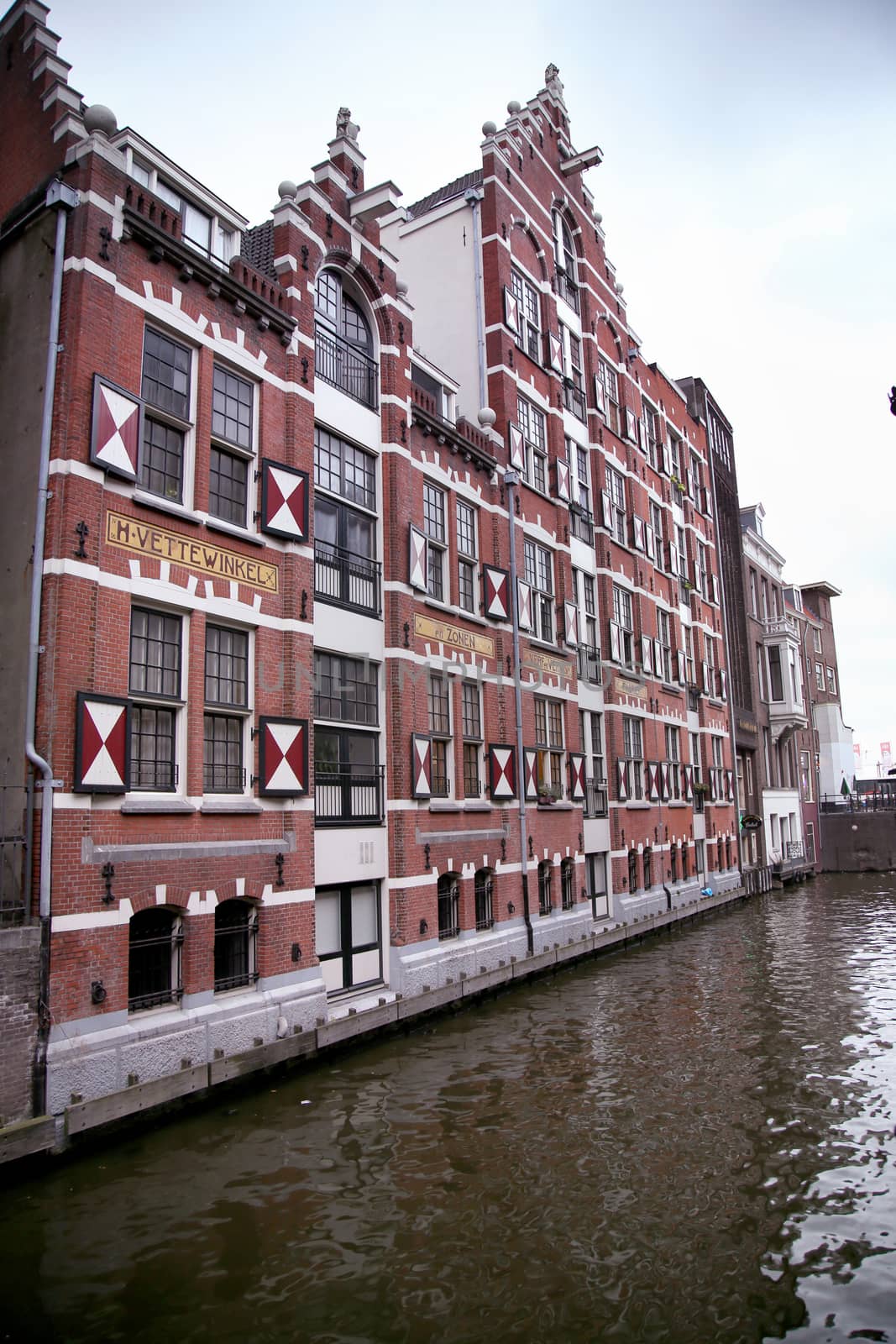 AMSTERDAM; THE NETHERLANDS - AUGUST 18; 2015: View on Oudezijds Kolk canal in Amsterdam, building Verf en Vernis Fabriek H.Vettewinke in Amsterdam. Amsterdam is capital of the Netherlands on August 18; 2015.