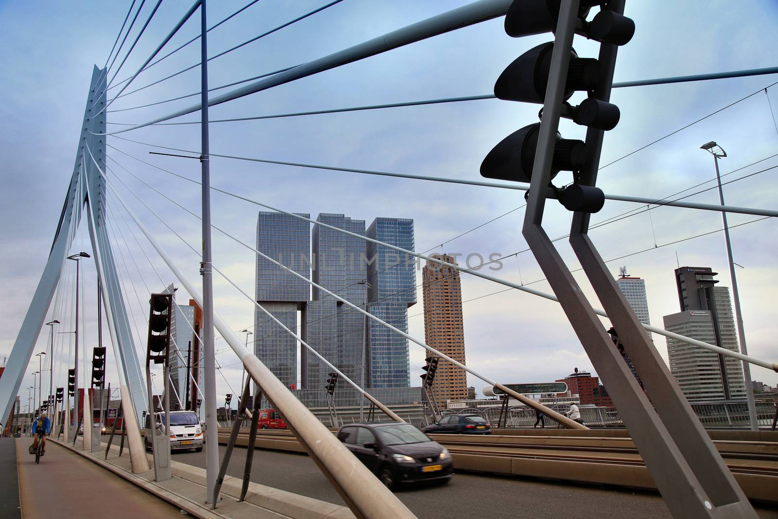 ROTTERDAM, THE NETHERLANDS - 18 AUGUST: Rotterdam is a city modern architecture. Cars traffic driving and bicyclists crossing on the Erasmus bridge (Erasmusbrug) in Rotterdam, Netherlands on August 18,2015.