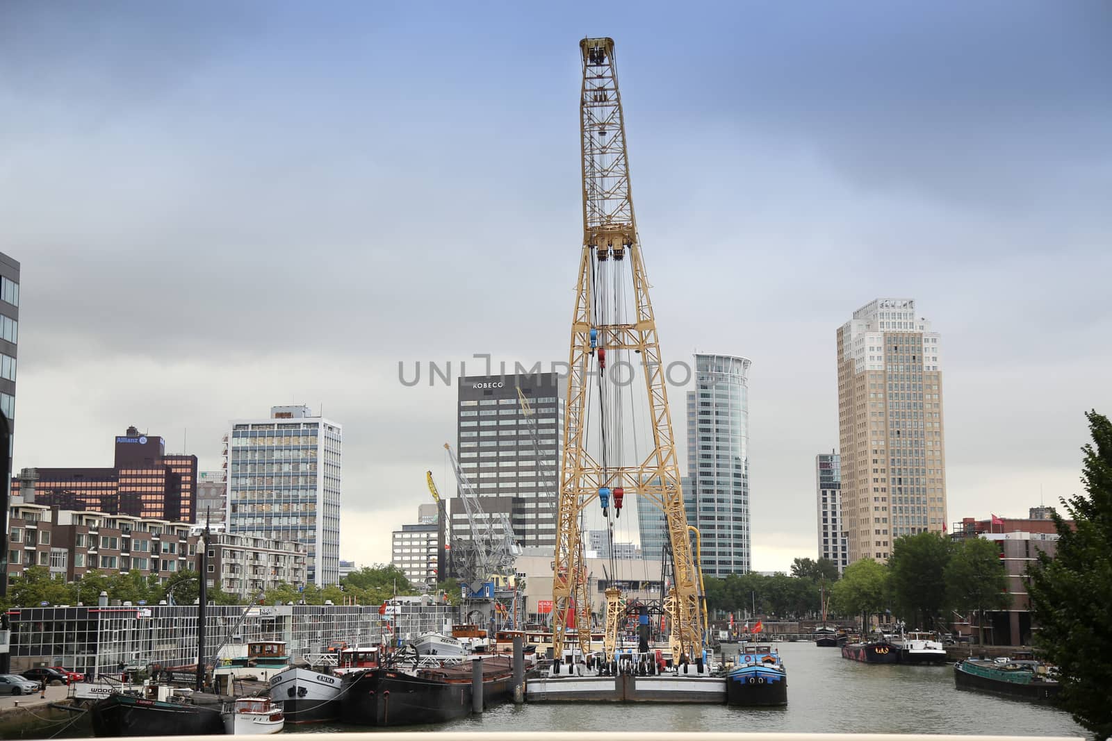 ROTTERDAM, THE NETHERLANDS - 18 AUGUST: Old cranes in Historical Leuvehaven, Rotterdam's oldest sea port. Harbor and modern apartment buildings in Rotterdam, Netherlands on August 18,2015.