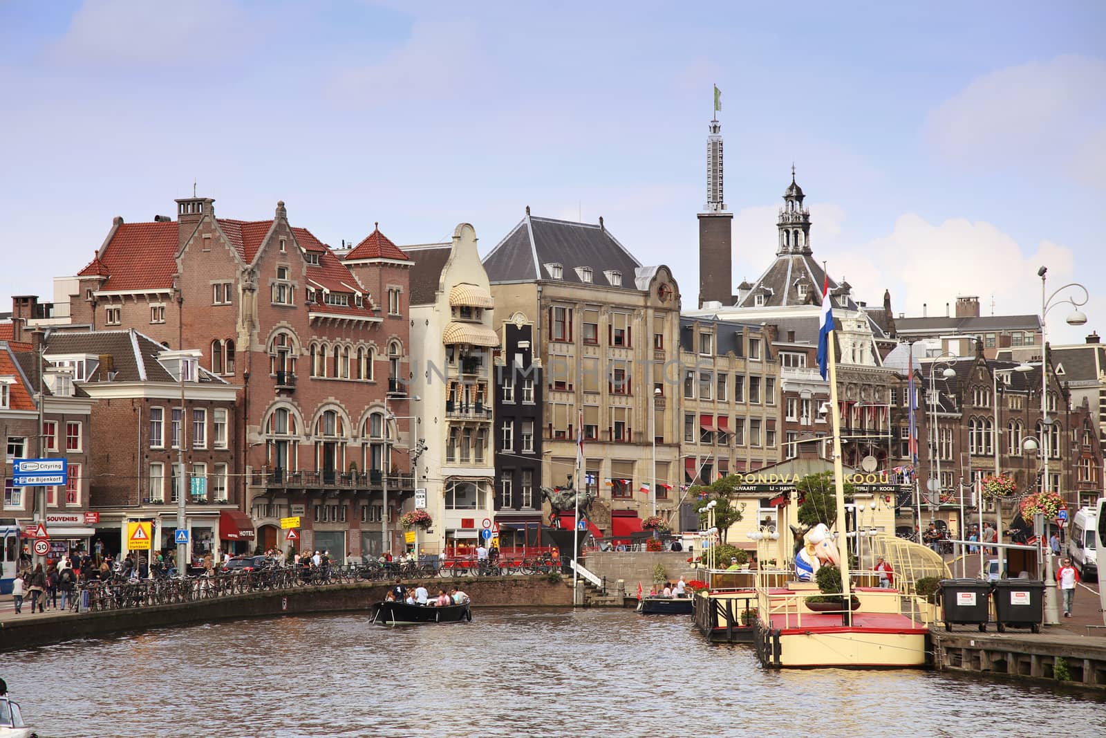 AMSTERDAM, THE NETHERLANDS - AUGUST 19, 2015: View on Rokin from bridge Doelensluis. Street life, Canal, tourists, bicycle and boat in Amsterdam. Amsterdam is capital of the Netherlands on August 19, 2015.