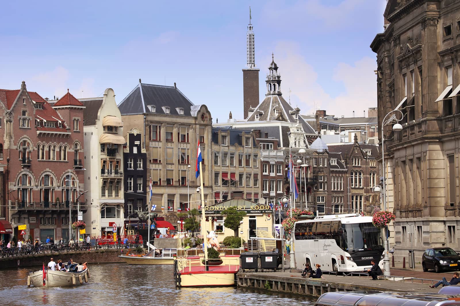 AMSTERDAM, THE NETHERLANDS - AUGUST 19, 2015: View on Rokin from bridge Doelensluis. Street life, Canal, tourists, bicycle and boat in Amsterdam. Amsterdam is capital of the Netherlands on August 19, 2015.