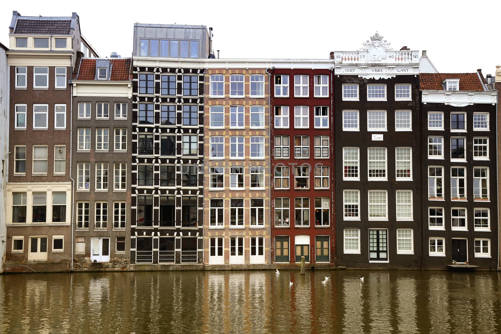 AMSTERDAM; THE NETHERLANDS - AUGUST 16; 2015: Beautiful views of the ancient buildings at the waterside, Damrak canal in Amsterdam. Amsterdam is capital of the Netherlands on August 16; 2015.
