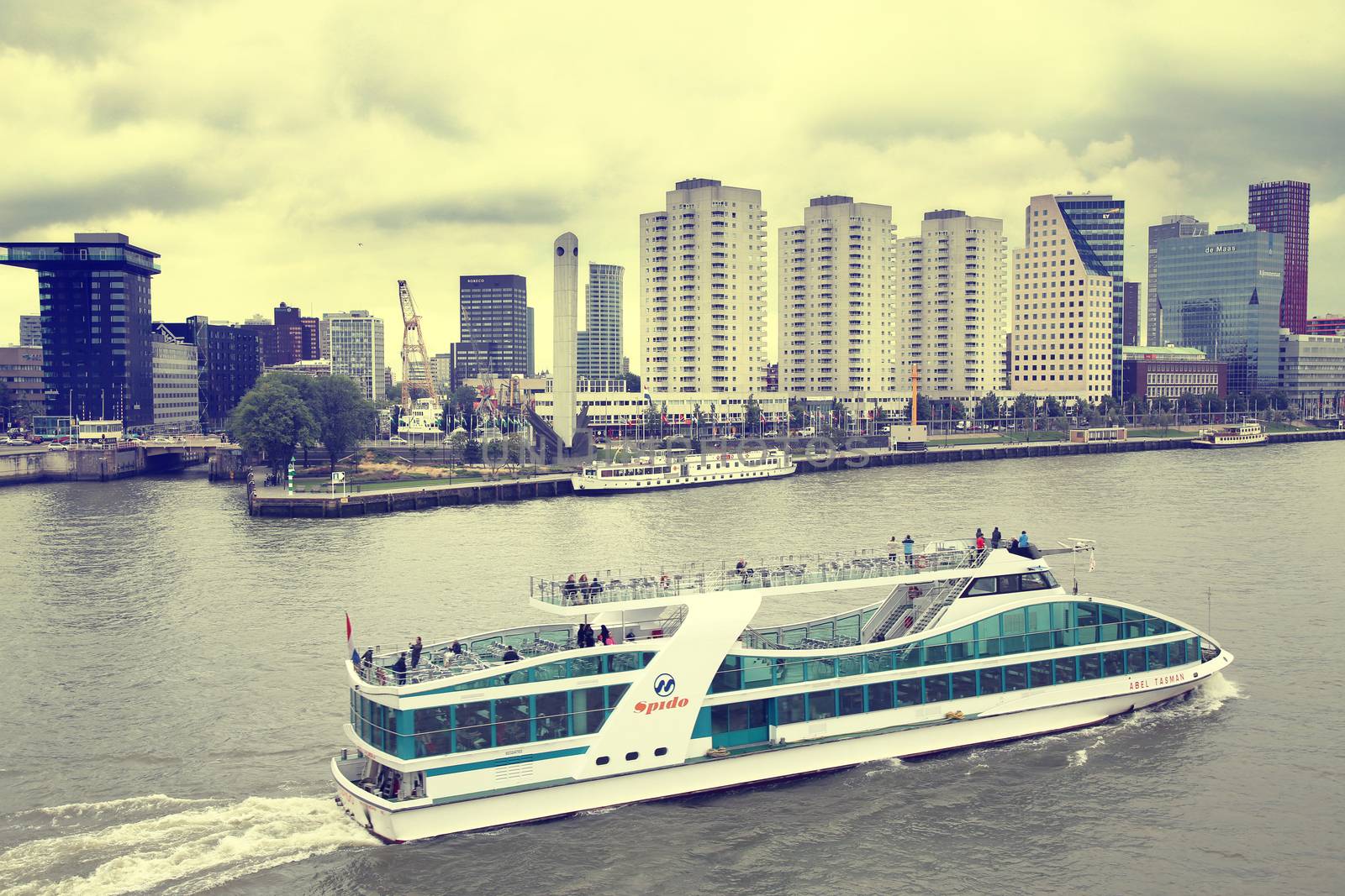 ROTTERDAM, THE NETHERLANDS - 18 AUGUST: View from Erasmus bridge on skyline of Rotterdam with a cruise boat, river Maas in Rotterdam, Netherlands on August 18,2015.