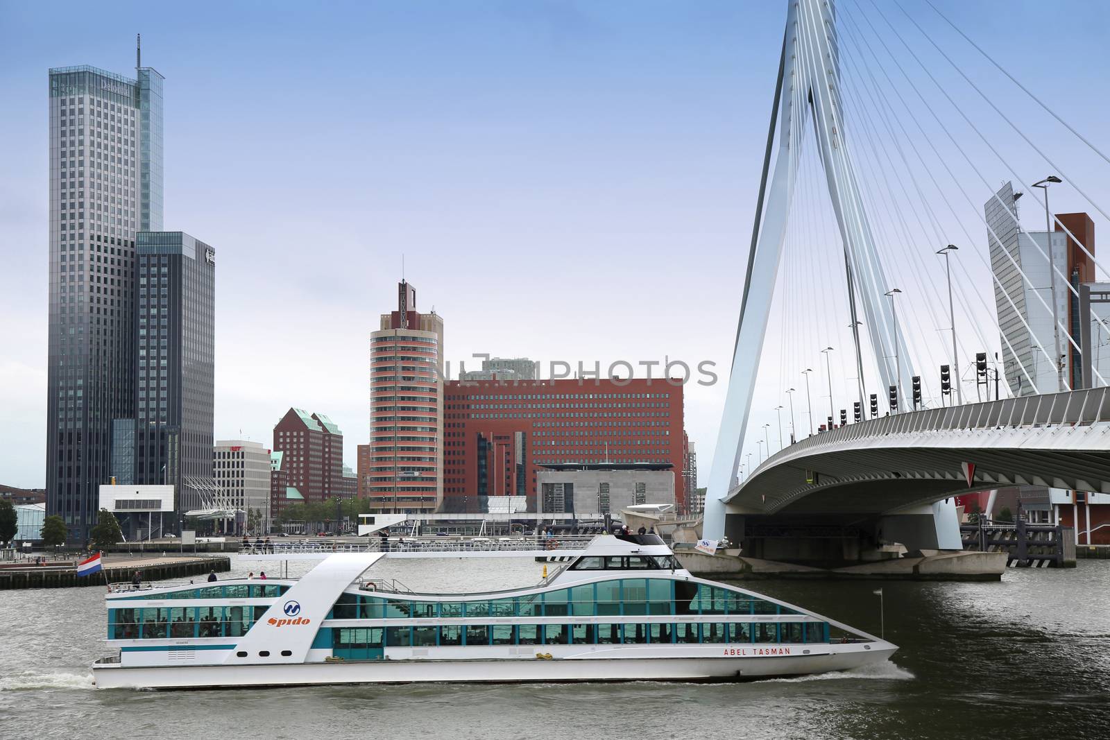 ROTTERDAM, THE NETHERLANDS - 18 AUGUST: Rotterdam is a city modern architecture, view on Erasmus Bridge (Erasmusbrug) and skyline of Rotterdam with a cruise boat, river Maas in Rotterdam, Netherlands on August 18,2015.