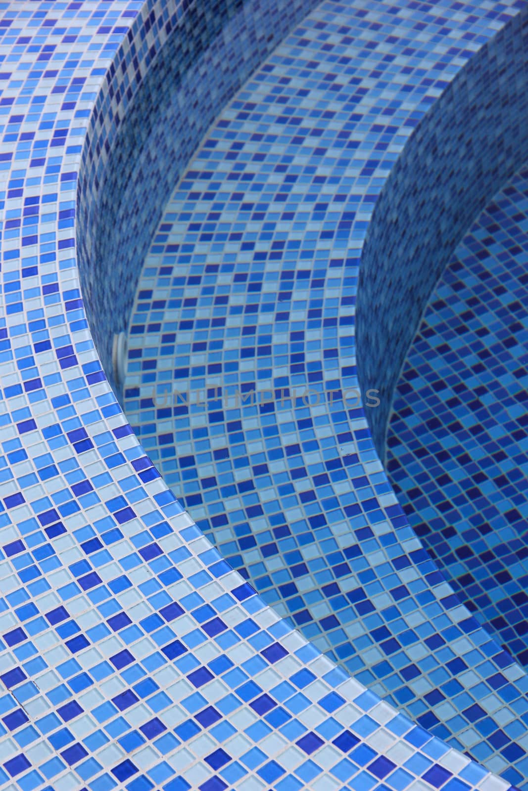 Curved steps at the swimming pool with blue tile mosaic