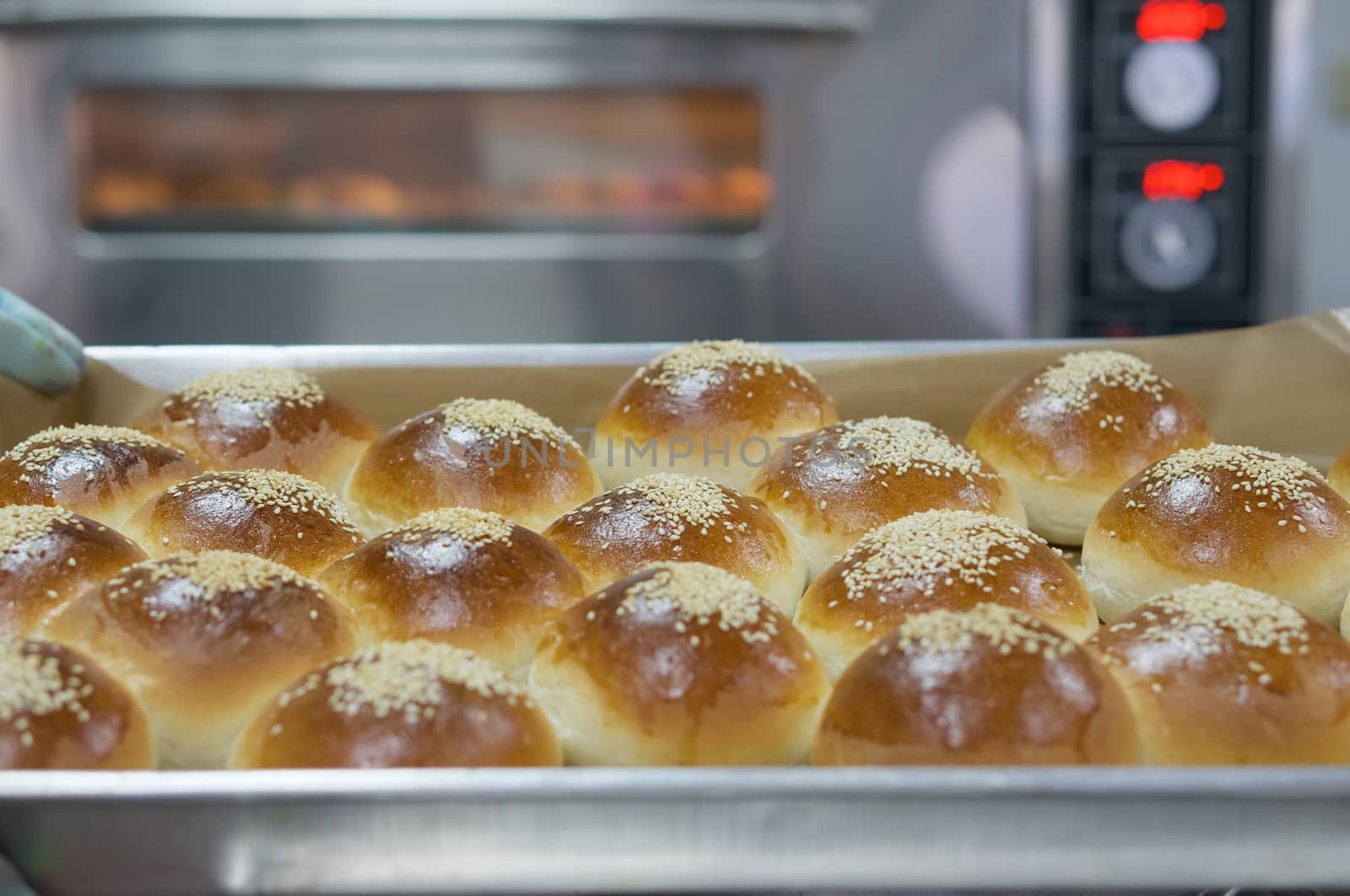 Dessert bread on top with sesame on stainless tray after baking in oven.