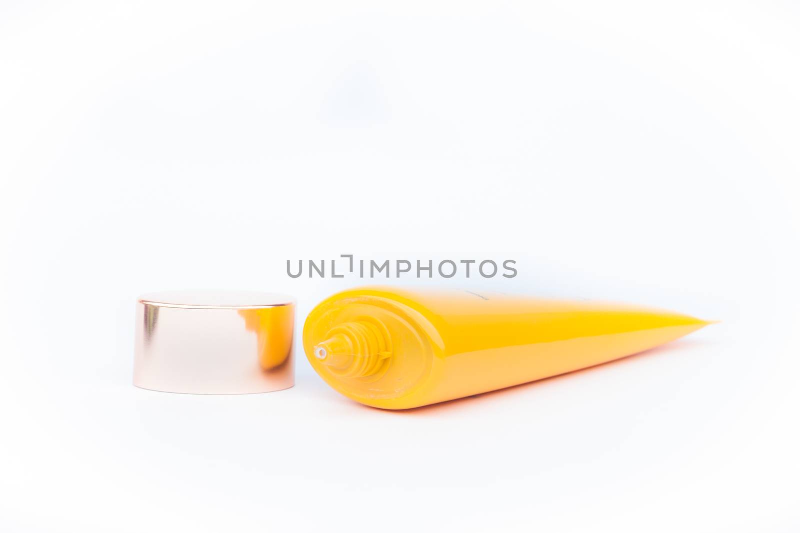 Tube container of sun cream on white background