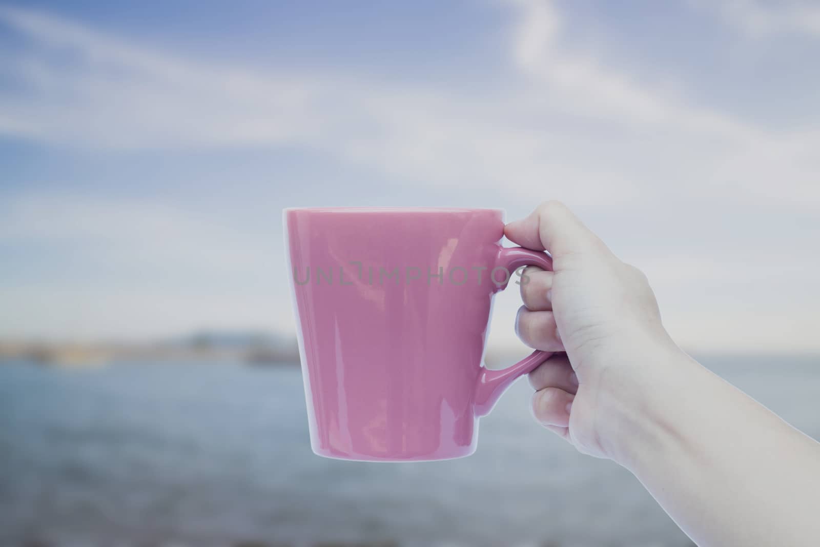 Woman hand holding coffee cup with blur deep blue background, stock photo