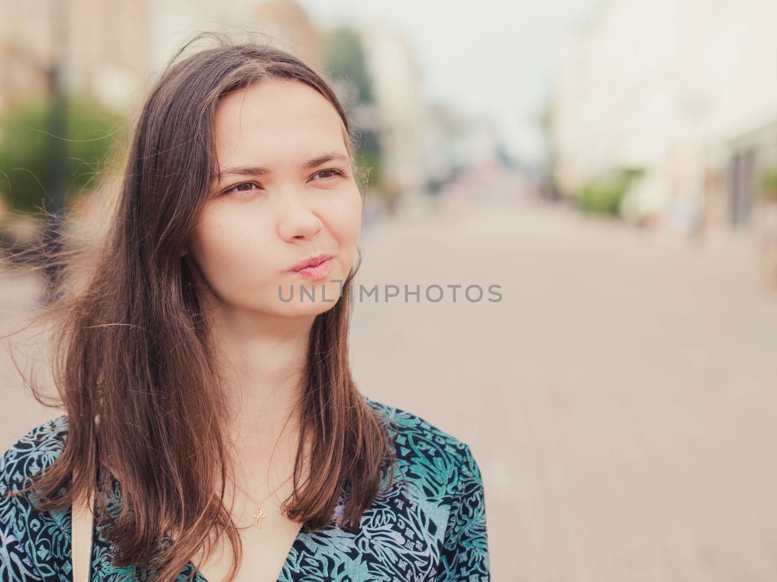 displeased handsome young woman looking away outdoors with copy space