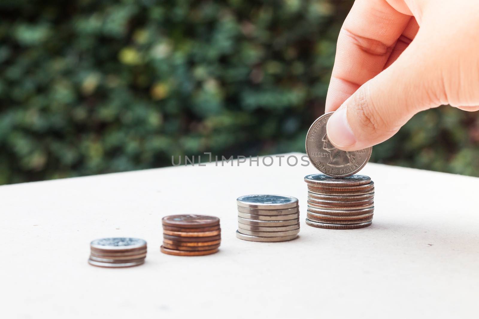 Woman hand putting money coin by punsayaporn