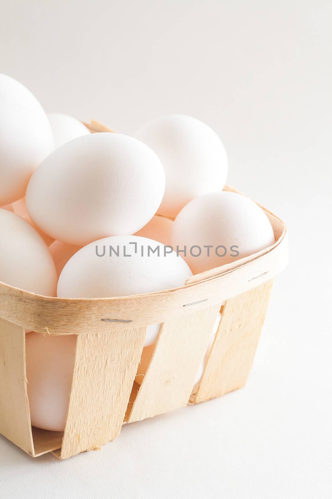 full basket of fresh eggs on a white background/