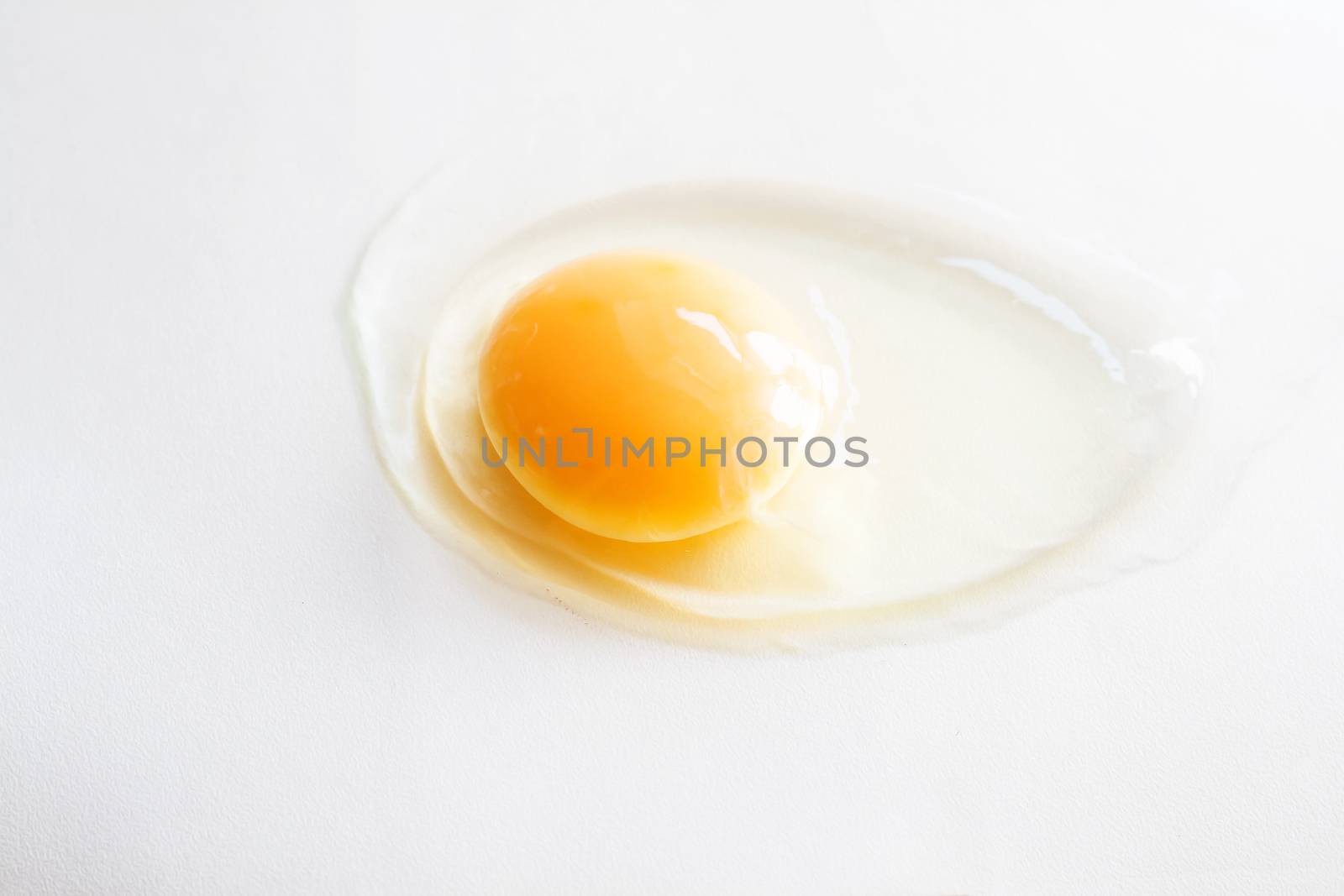 white egg is broken and leaked on a white background..