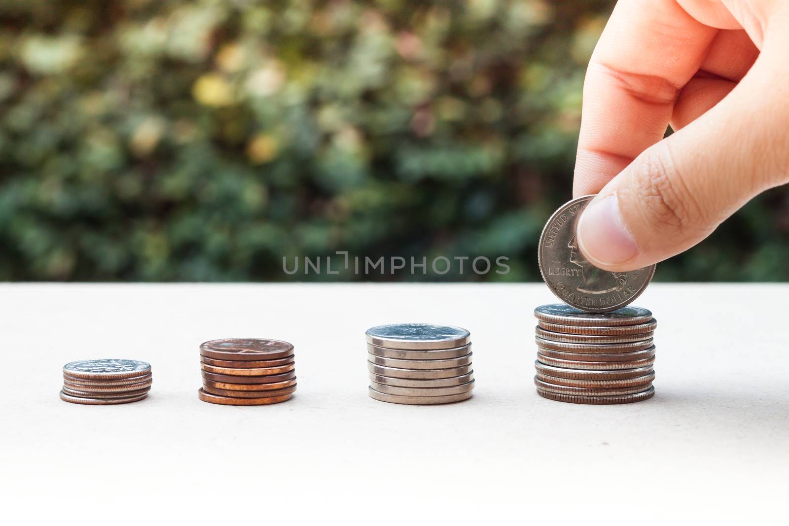 Woman hand putting money coin for saving money concept