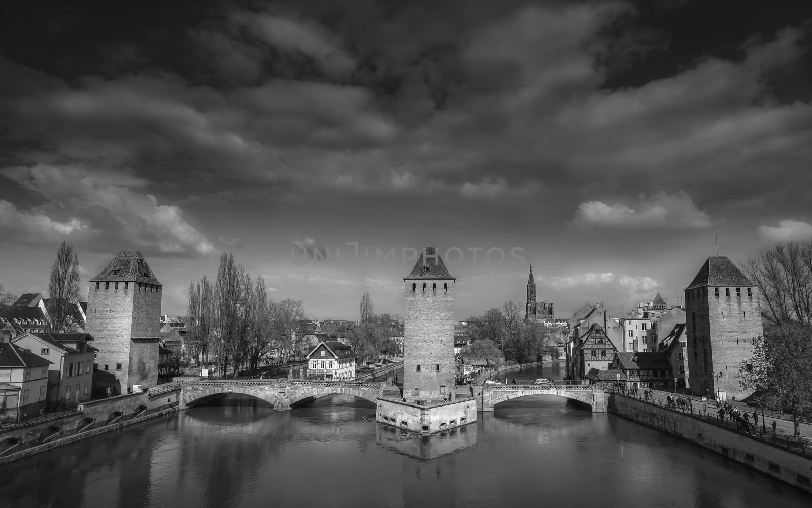 Black and white image of "Les ponts couverts" (the covered bridges), Strasbourg, Alsace, France, with a dramatic cloudscape.