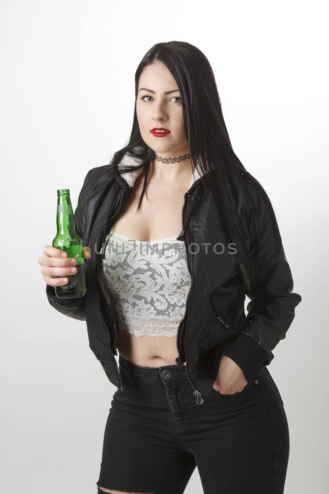Sexy young woman in her twentie holding a green bottle of beer