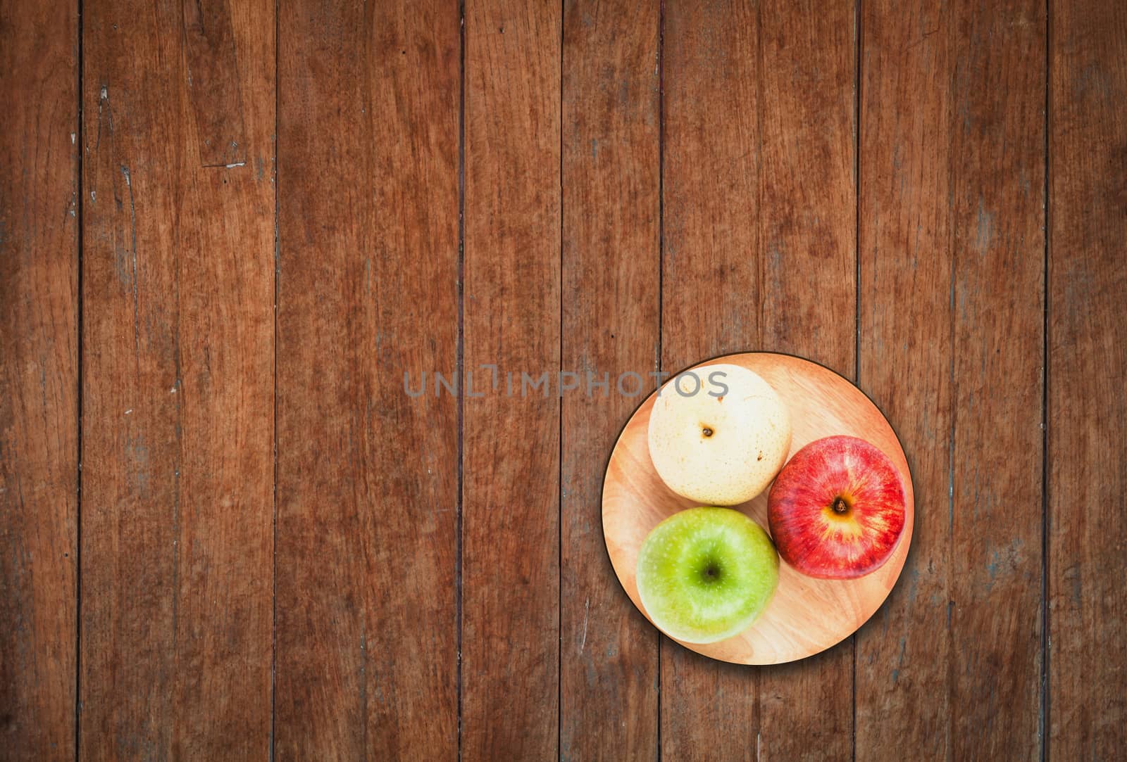 Top view of three different kind of apples on wooden background