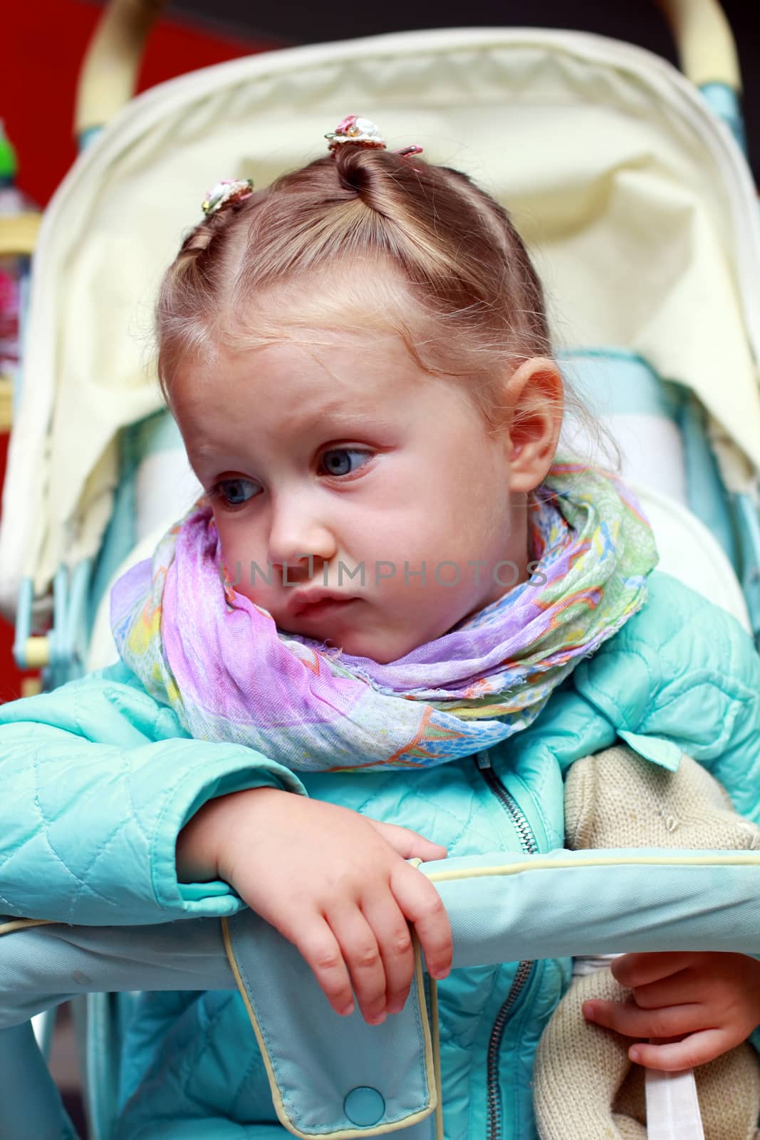 Dissatisfied little girl in a pushchair by friday