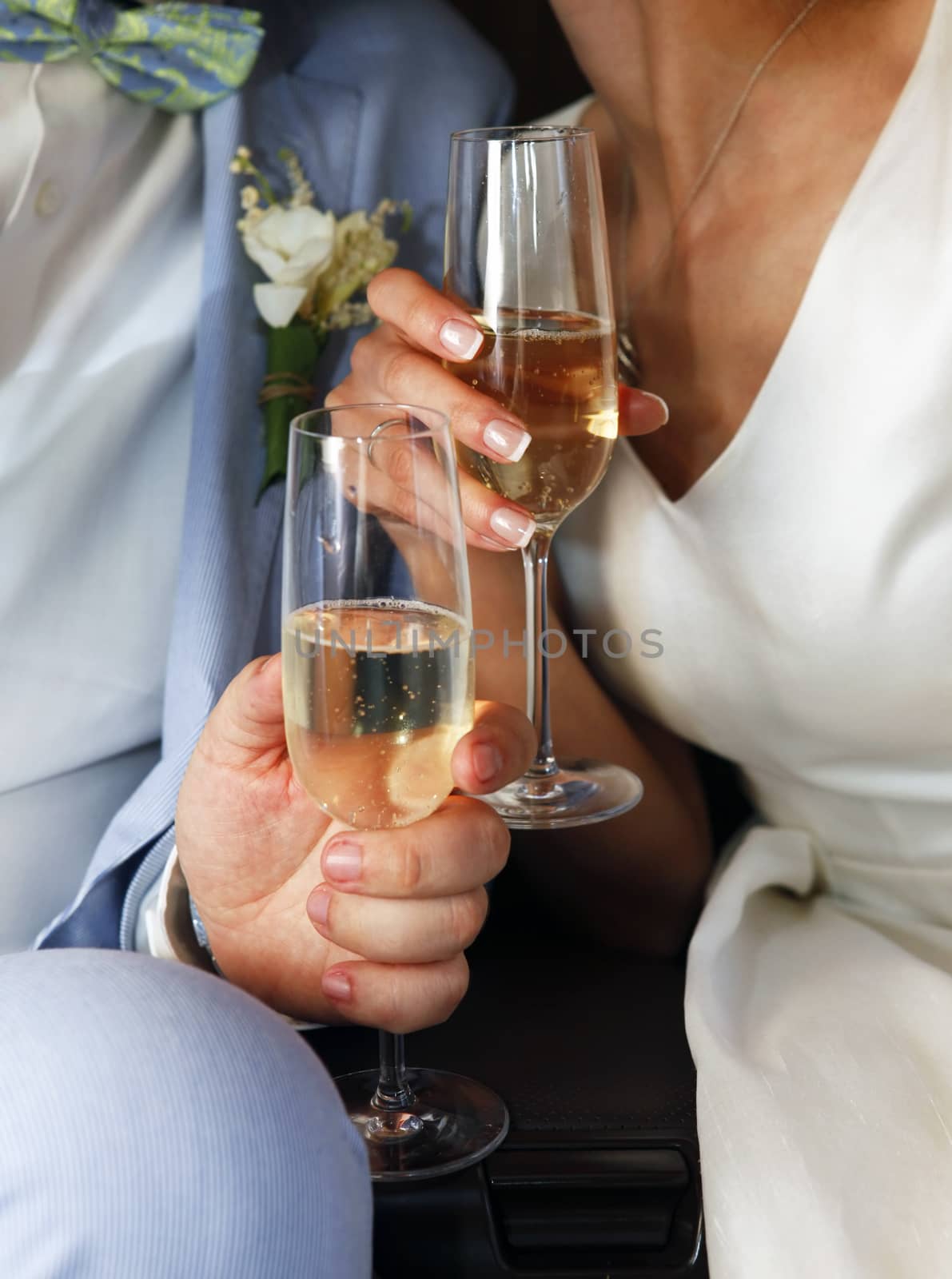 Glass of champagne in a hands of the groom and bride
