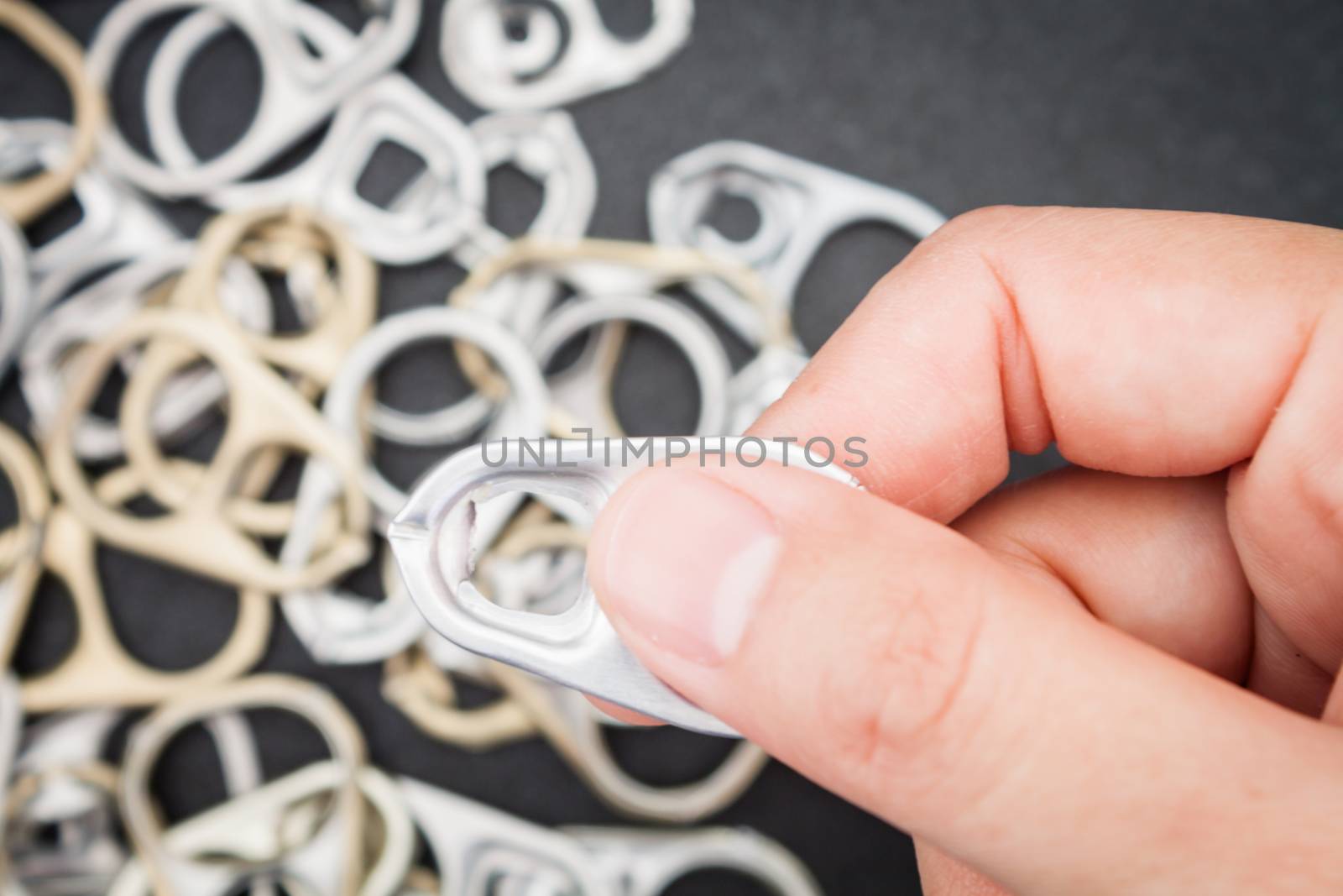 Woman hand holding ring pull cans opener background by punsayaporn