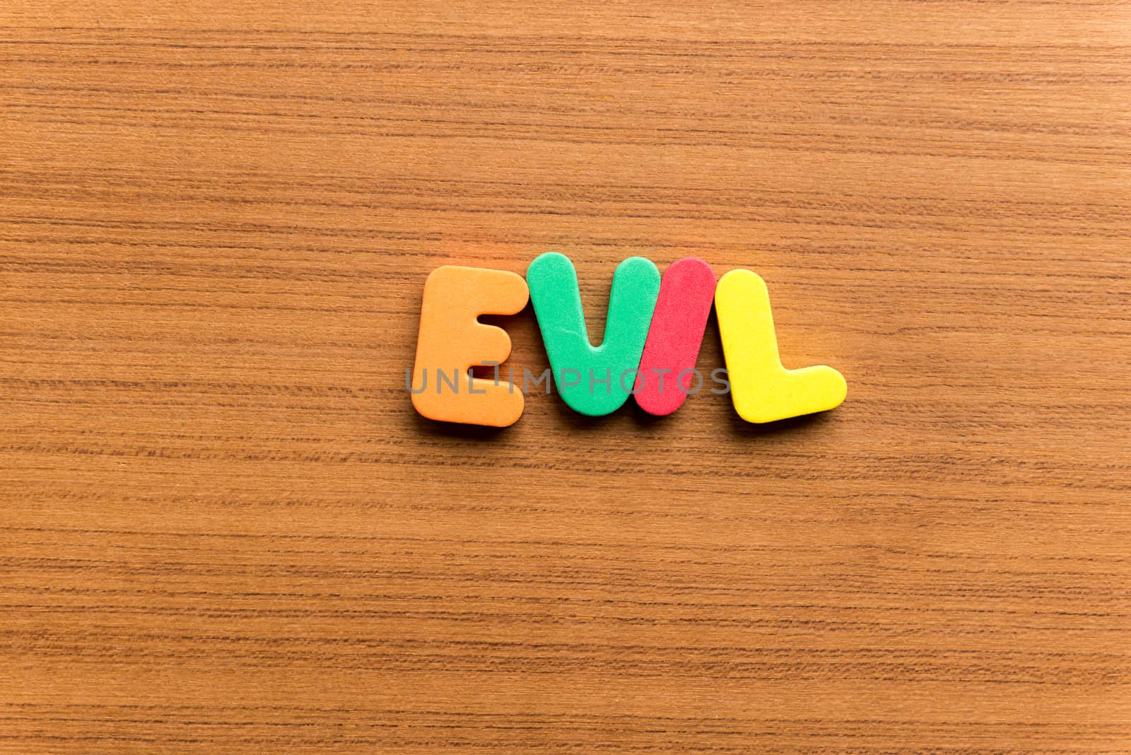 evil colorful word on the wooden background