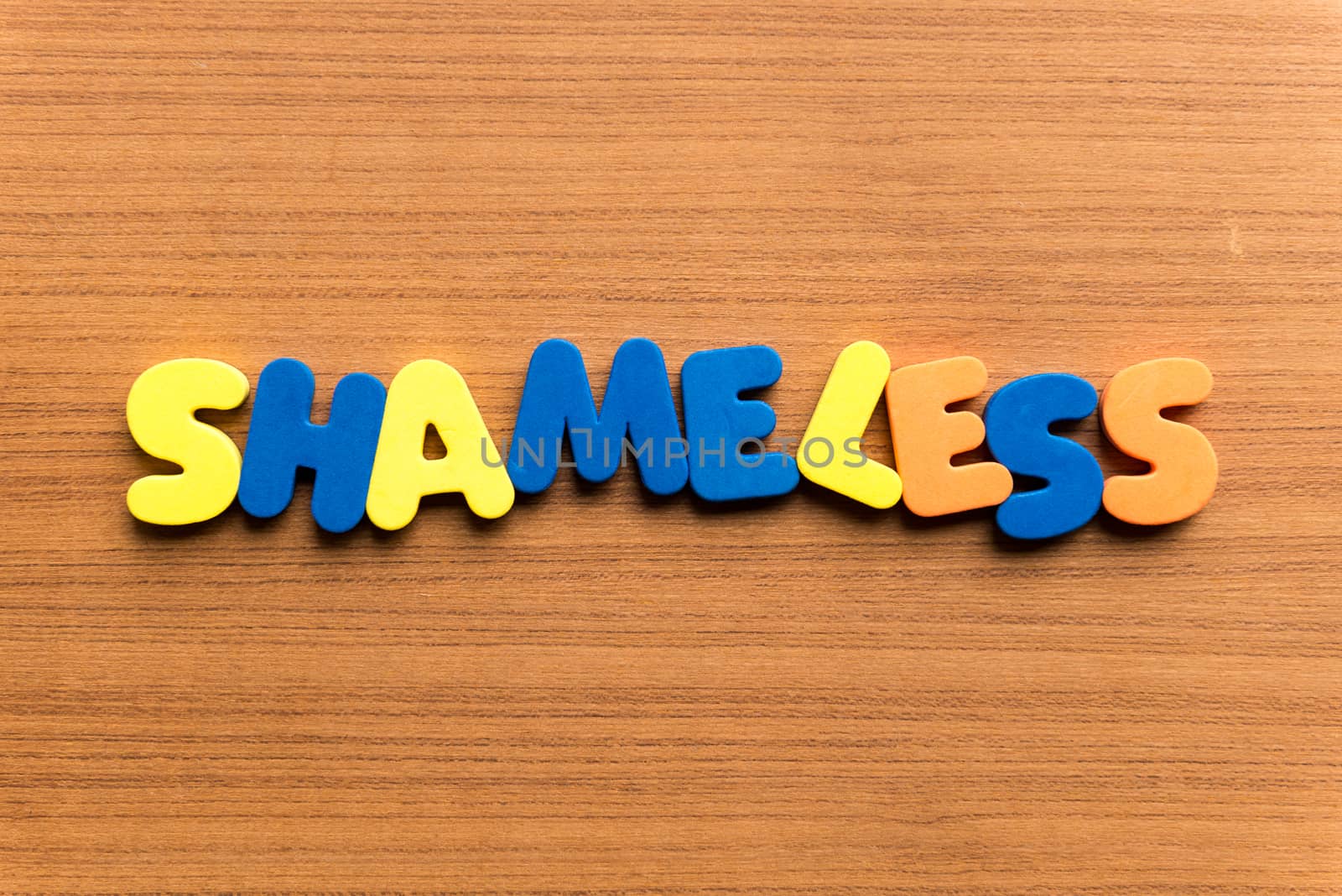shameless colorful word on the wooden background