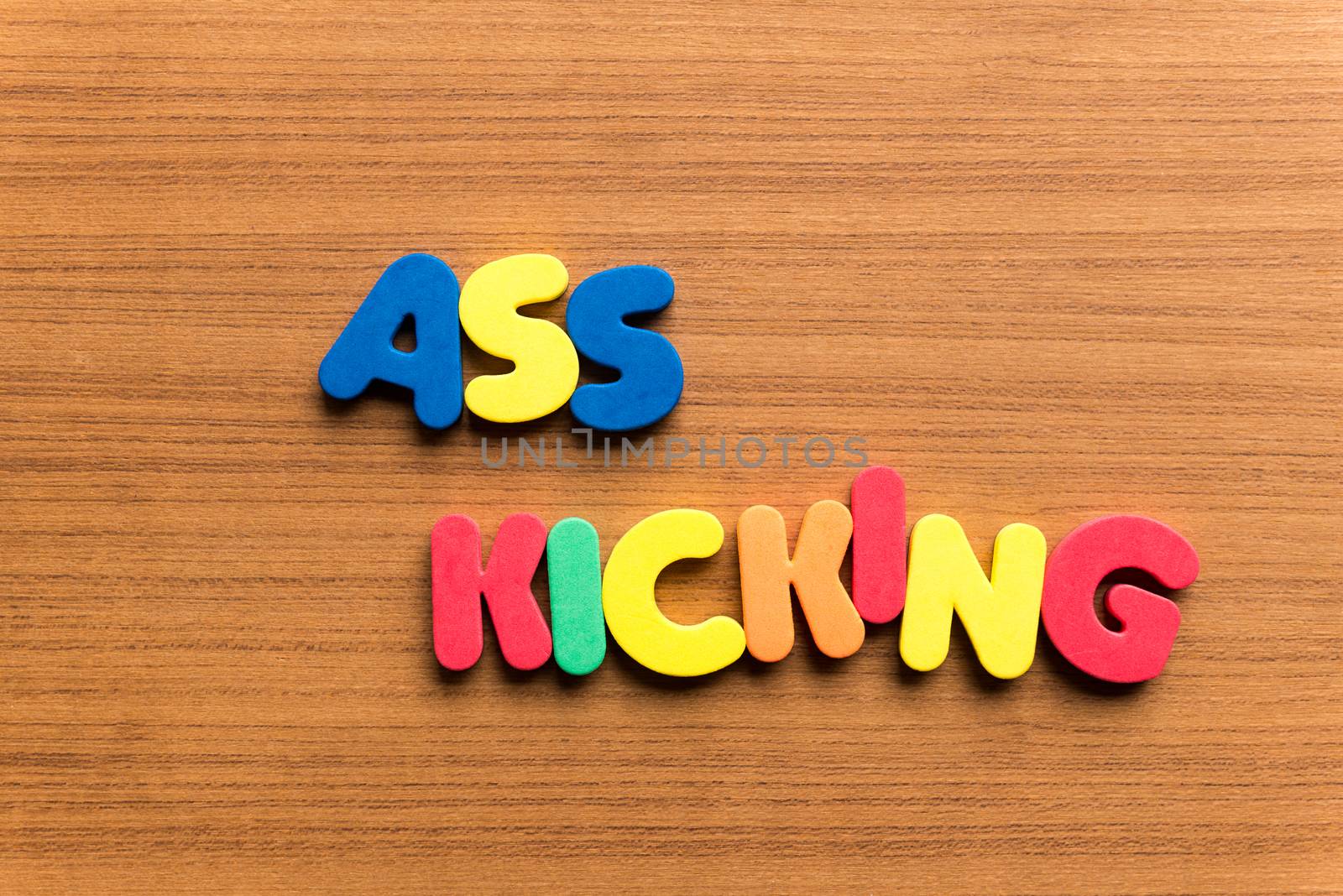 ass kicking colorful word on the wooden background