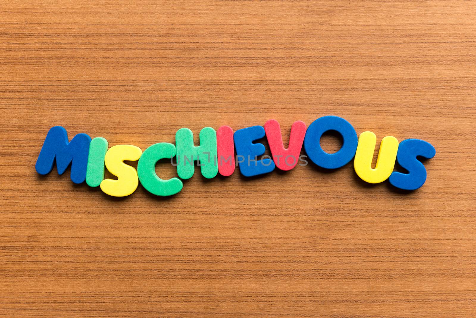 mischievous colorful word on the wooden background