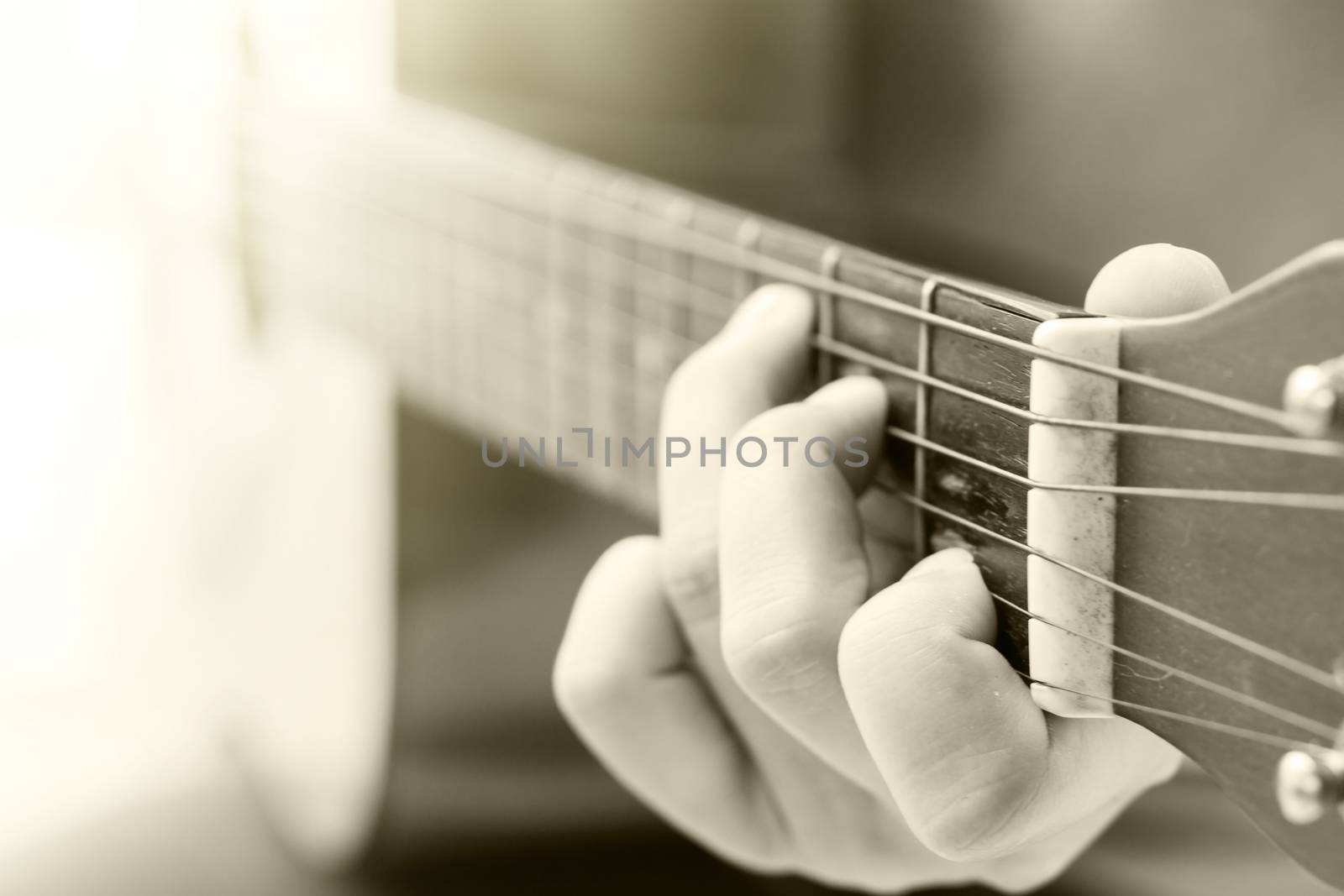 Woman's hands playing acoustic guitar with vintage filter, stock photo