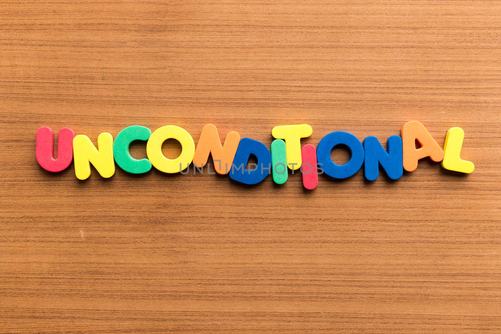unconditional colorful word on the wooden background