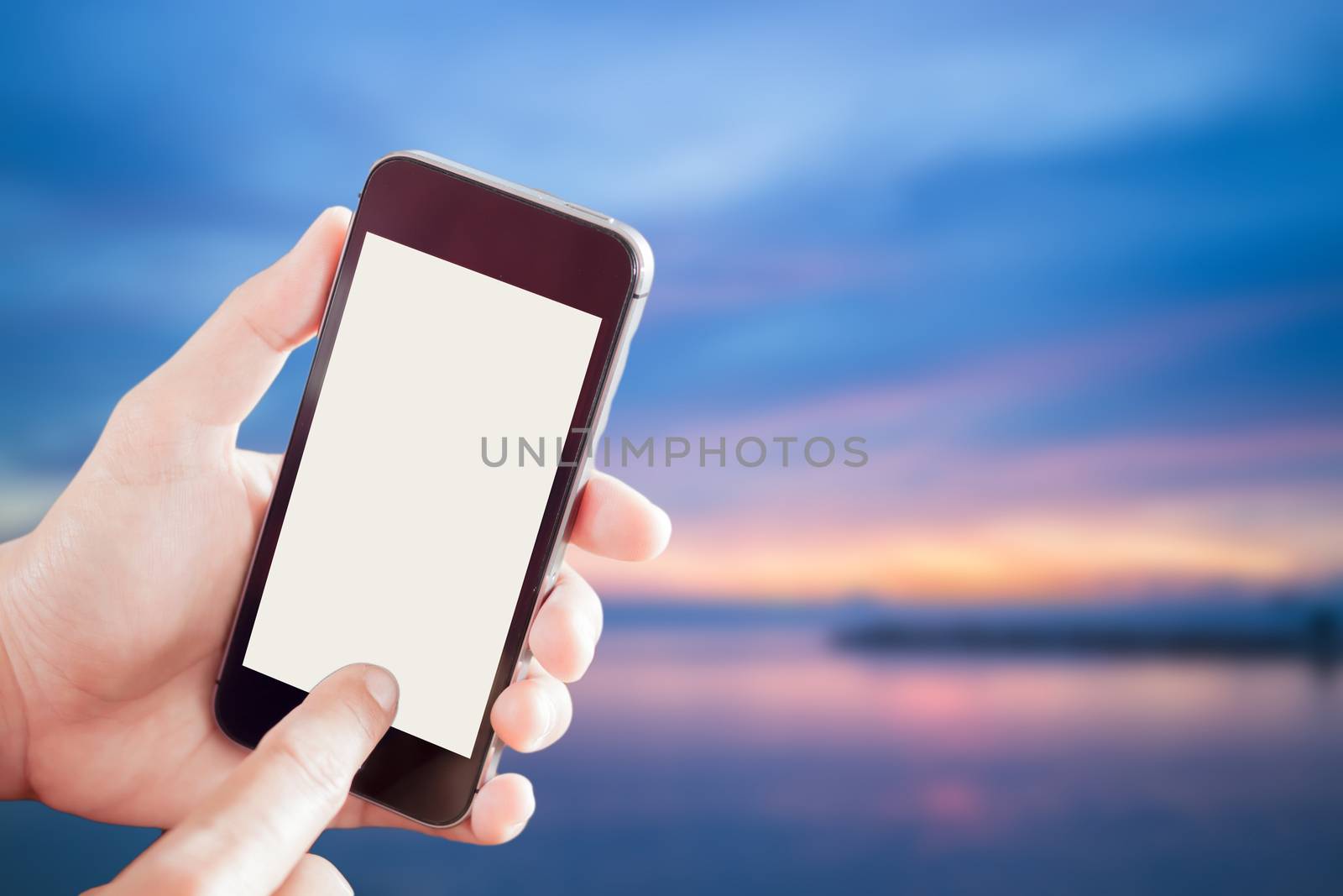 Woman using smartphone with sunset blur background  by punsayaporn