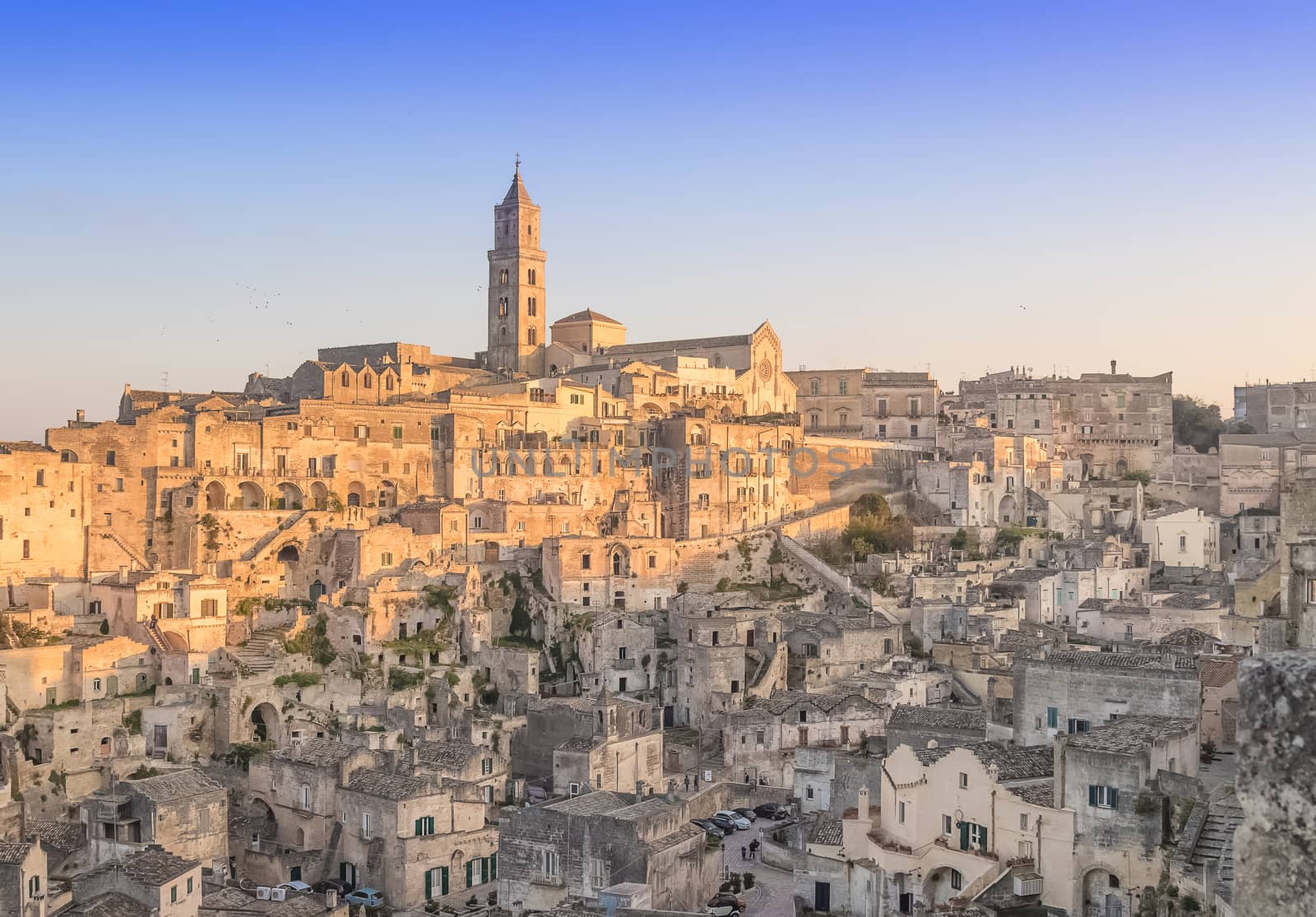 panoramic view of typical stones and church of Matera under begin sunset sky. Basilicata, Italy