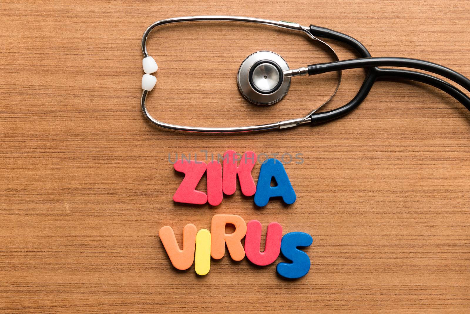 zika virus colorful word with stethoscope on wooden background