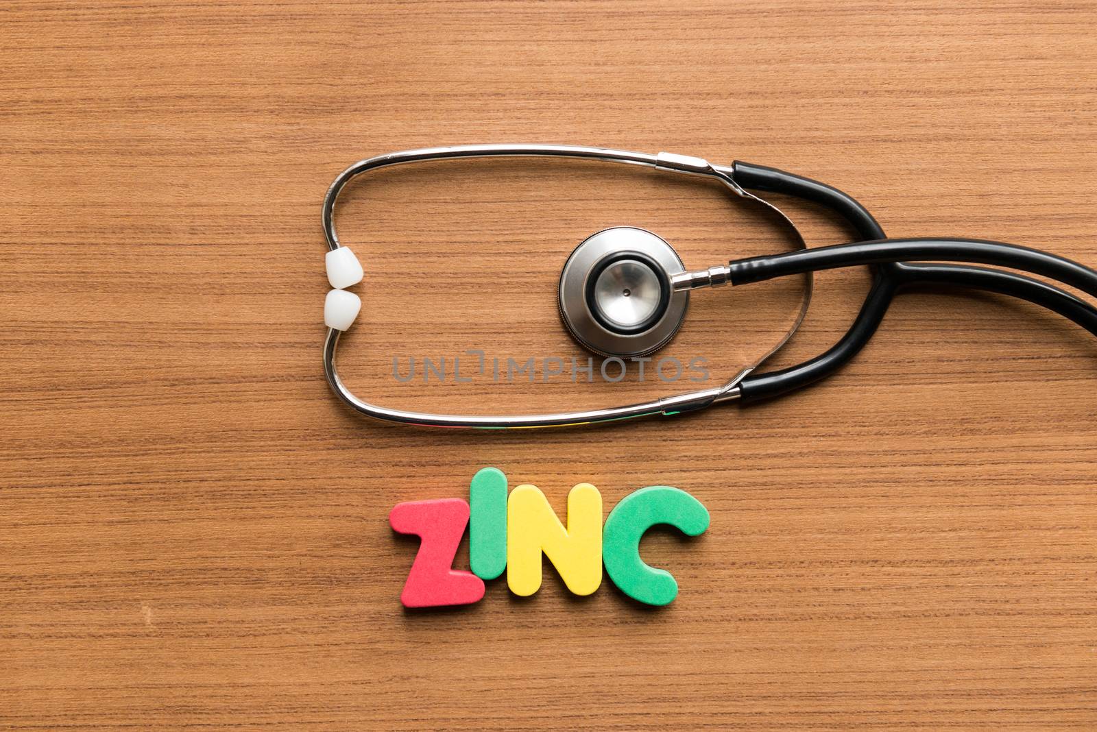 zinc colorful word with stethoscope on wooden background