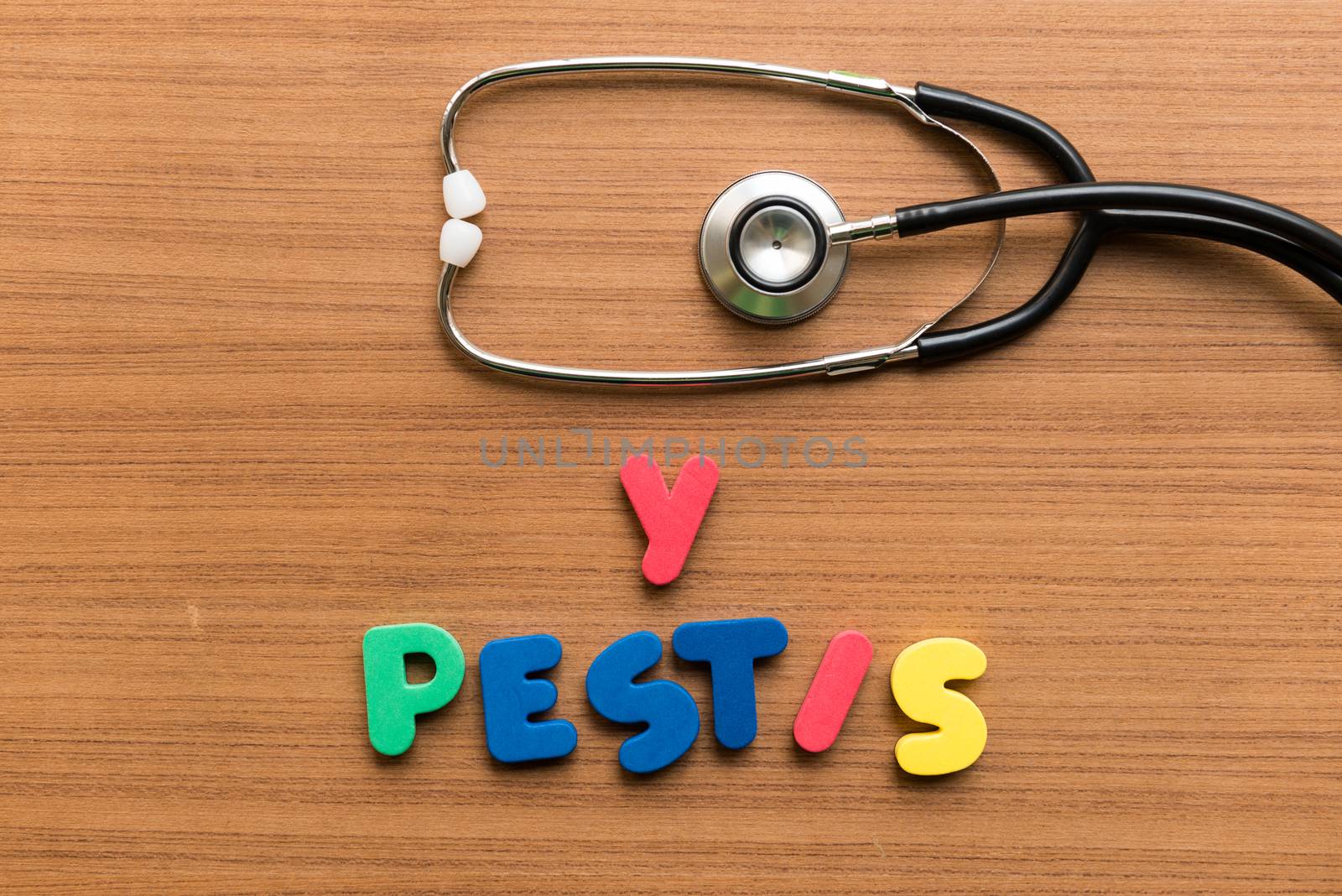y pestis colorful word with stethoscope on wooden background