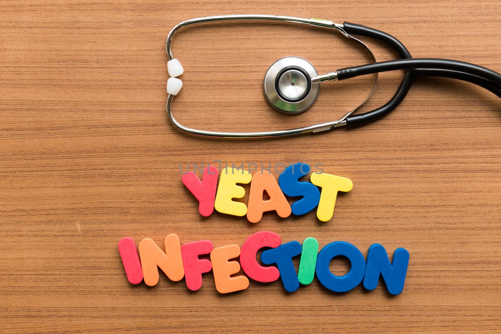 yeast infection colorful word with stethoscope on wooden background